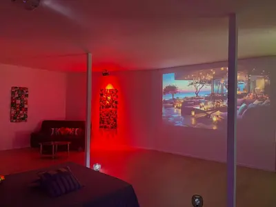 a living room with red lighting and a room with a table at Le Luxe in Fléron
