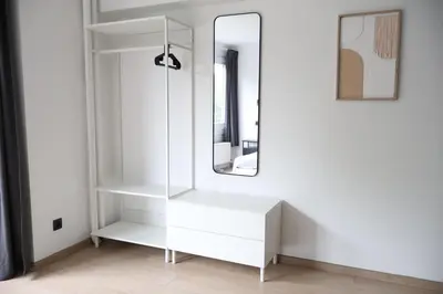 a dressing room with a mirror and white shelves at Le Carlton in Liège