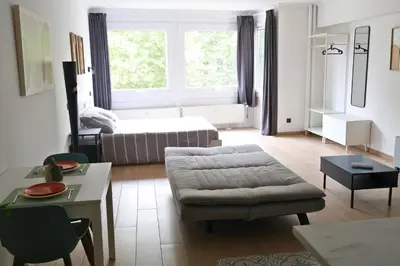 a living room with a couch and a bed at Le Carlton in Liège