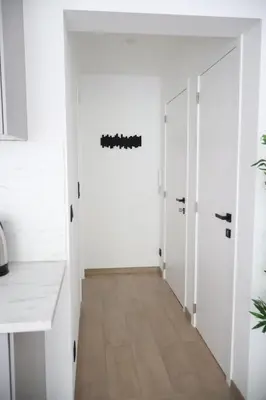 a hallway with white walls and wood floors at Le Carlton in Liège
