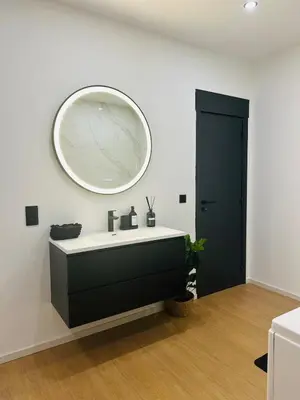 a bathroom with a sink and a mirror on the wall at Élégant appartement avec bain balnéothérapie in Liège