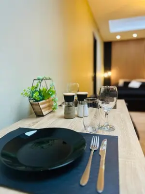 a table with a black plate and a fork and knife at Élégant appartement avec bain balnéothérapie in Liège
