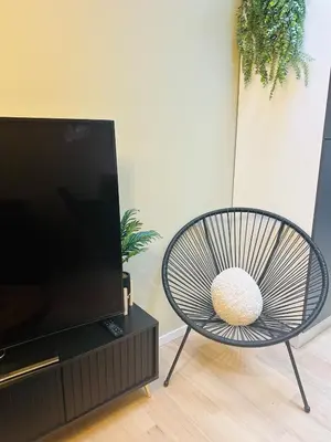 a chair sitting in front of a flat screen tv at Élégant appartement avec bain balnéothérapie in Liège