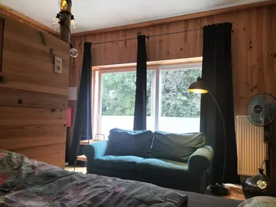 a bedroom with a couch in front of a window at B&B Halen in Halen