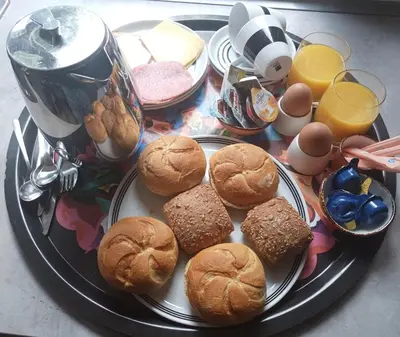 a plate of food with sandwiches and eggs and drinks at B&B Halen in Halen
