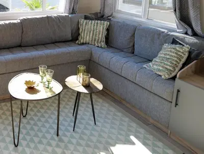 a blue couch with two tables in a living room at Camping Zavelbos Superior Chalet in Maaseik