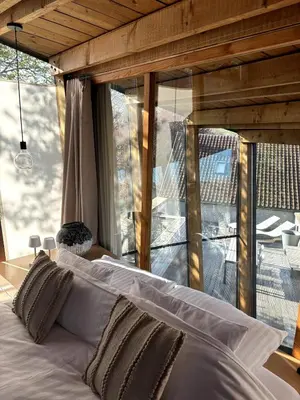 a bed in a room with a large window at Art'lette Loft Balneo Bath & Infrared Sauna in Herve