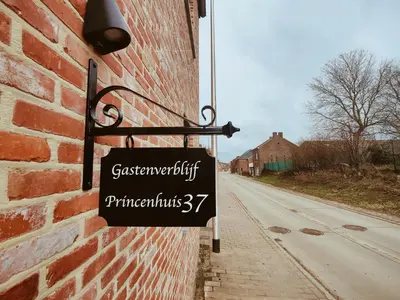 a sign hanging on the side of a brick building at Princenhuis37 in Tongeren