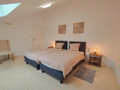 a bedroom with a large bed with two lamps on it at Princenhuis37 in Tongeren