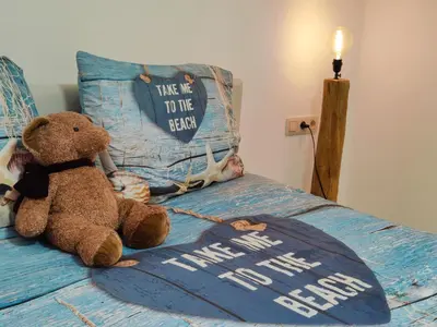 a teddy bear sitting on a bed with a pillow at Princenhuis37 in Tongeren