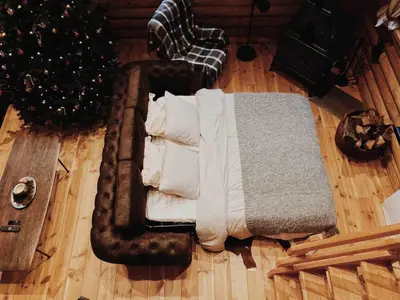 a bed sitting on the floor next to a christmas tree at Le chalet Nord in Verviers