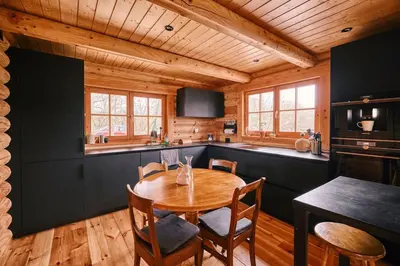 a kitchen with a table and chairs in a cabin at Le chalet Nord in Verviers