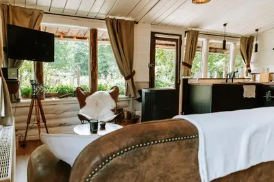 a room with a chair and a table with a cup at Le chalet Sud in Verviers