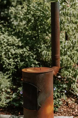 a fire hydrant sitting on the side of a garden at Le chalet Sud in Verviers