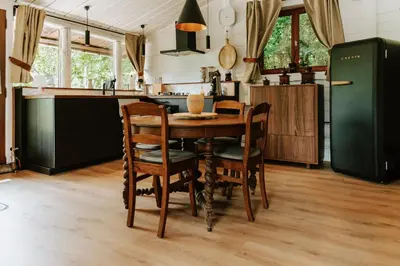 a kitchen with a table and chairs and a refrigerator at Le chalet Sud in Verviers