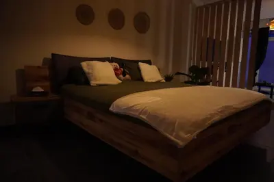 a bed with a teddy bear sitting on top of it at SpaNChill in Herstal