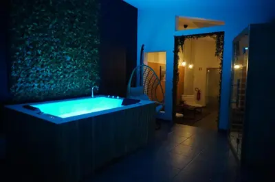 a bathroom with a tub in a dark room at SpaNChill in Herstal