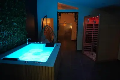 a bathroom with a large tub in the middle of a room at SpaNChill in Herstal