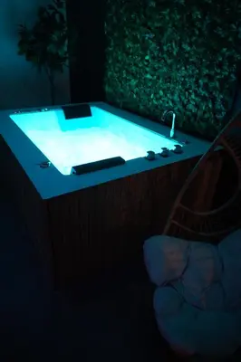a hot tub in a dark room with a sink at SpaNChill in Herstal