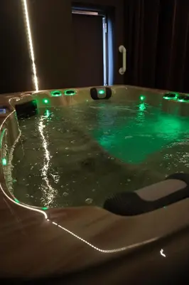a jacuzzi tub with green lights on it at Spa&Chill in Seraing
