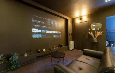 a living room with a couch and a large screen at Spa&Chill in Seraing
