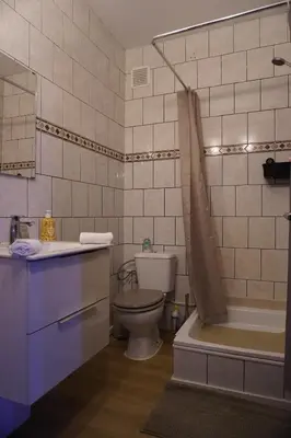 a bathroom with a toilet and a tub and a sink at ChambreNchill in Seraing