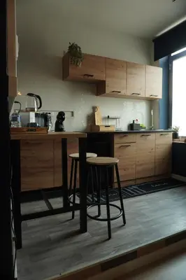 a kitchen with wooden cabinets and a table and chairs at ChambreNchill in Seraing