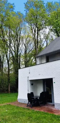 a white building with a table and chairs in it at Vakantiebungalow BERK 1 in Houthalen-Helchteren