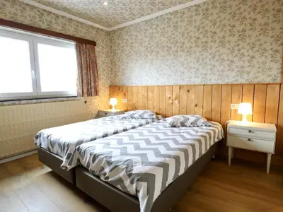 two beds in a bedroom with two lamps on tables at Halinsart in Trooz
