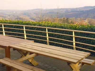 a wooden bench sitting next to a fence at Halinsart in Trooz