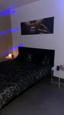 a bedroom with a bed with a poster on the wall at La home Gold Jacuzzi in Seraing
