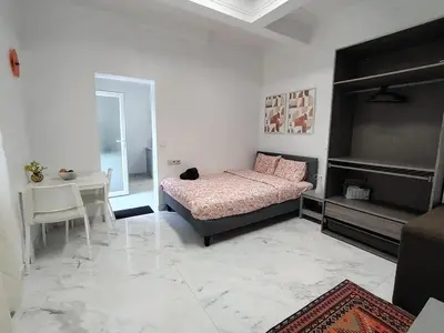 a bedroom with a bed and a table and a desk at Spacious, warm and cozy studio in Heers
