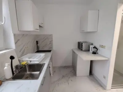 a small white kitchen with a sink and a counter at Spacious, warm and cozy studio in Heers