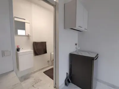 a white bathroom with a sink and a mirror at Spacious, warm and cozy studio in Heers