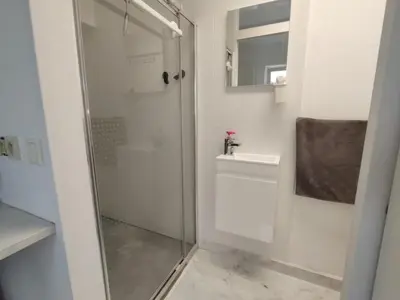 a bathroom with a shower and a glass door at Spacious, warm and cozy studio in Heers