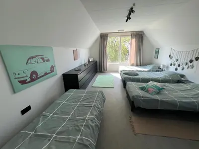 a bedroom with two beds and a room with a van on the wall at GT Lounge Zolder in Heusden - Zolder