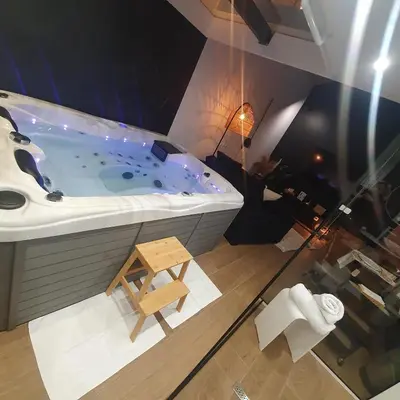 a large bath tub in a room with a table at Ô voda in Waremme