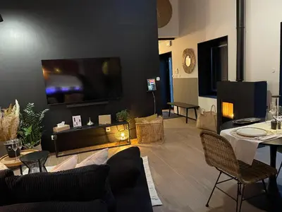 a living room with a couch and a tv on a wall at Ô voda in Waremme