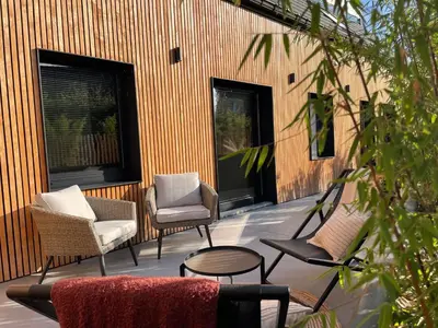 a patio with chairs and tables and windows at Ô voda in Waremme