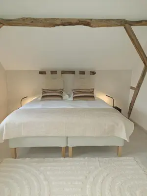 a bedroom with a large white bed in a room at Hoeve BôThé - Vakantiewoning in Alken