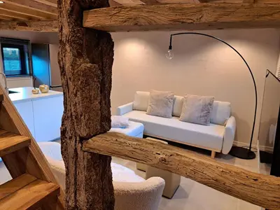 a living room with a white couch and a lamp at Hoeve BôThé - Vakantiewoning in Alken