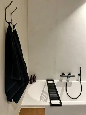 a bathroom with a bath tub with a black towel at Zalig HASPENGOUW in Sint-Truiden