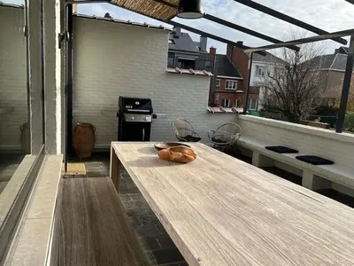 a wooden table on a balcony with a stove at Zalig HASPENGOUW in Sint-Truiden