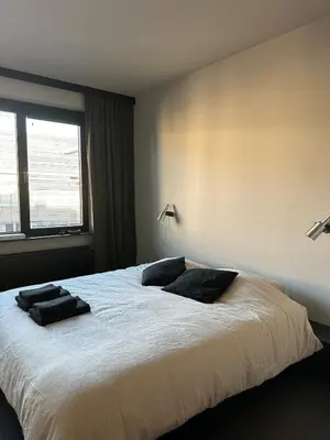 a bedroom with a large bed with two pillows on it at Zalig HASPENGOUW in Sint-Truiden