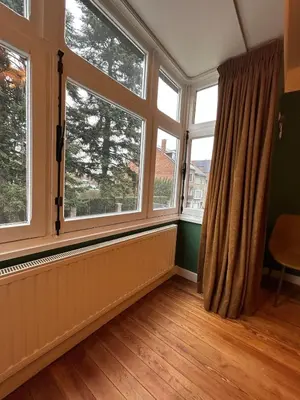 a room with two large windows and a wooden floor at Vakantiehuis Twenty Six in Hasselt