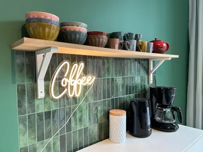 a shelf with a coffee sign on a green wall at Vakantiehuis Twenty Six in Hasselt