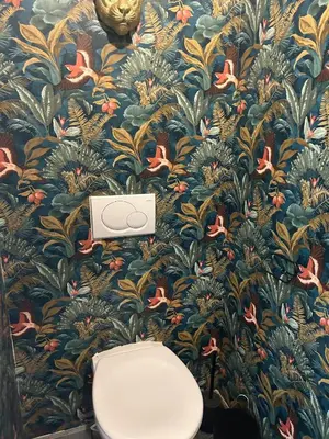 a bathroom with a flower wallpaper with a toilet at Vakantiehuis Twenty Six in Hasselt