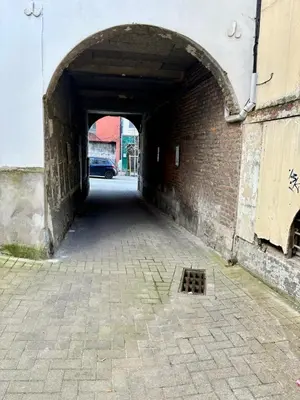 a tunnel with a brick wall and an arch way at Aux portes du marché in Verviers