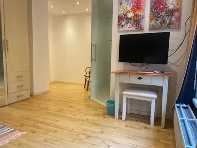 a room with a desk with a television on it at Tweekamer Apartement in Dilsen-Stokkem
