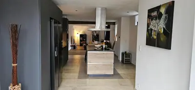 a hallway of a home with a kitchen and a living room at Comme chez Soi in Liège